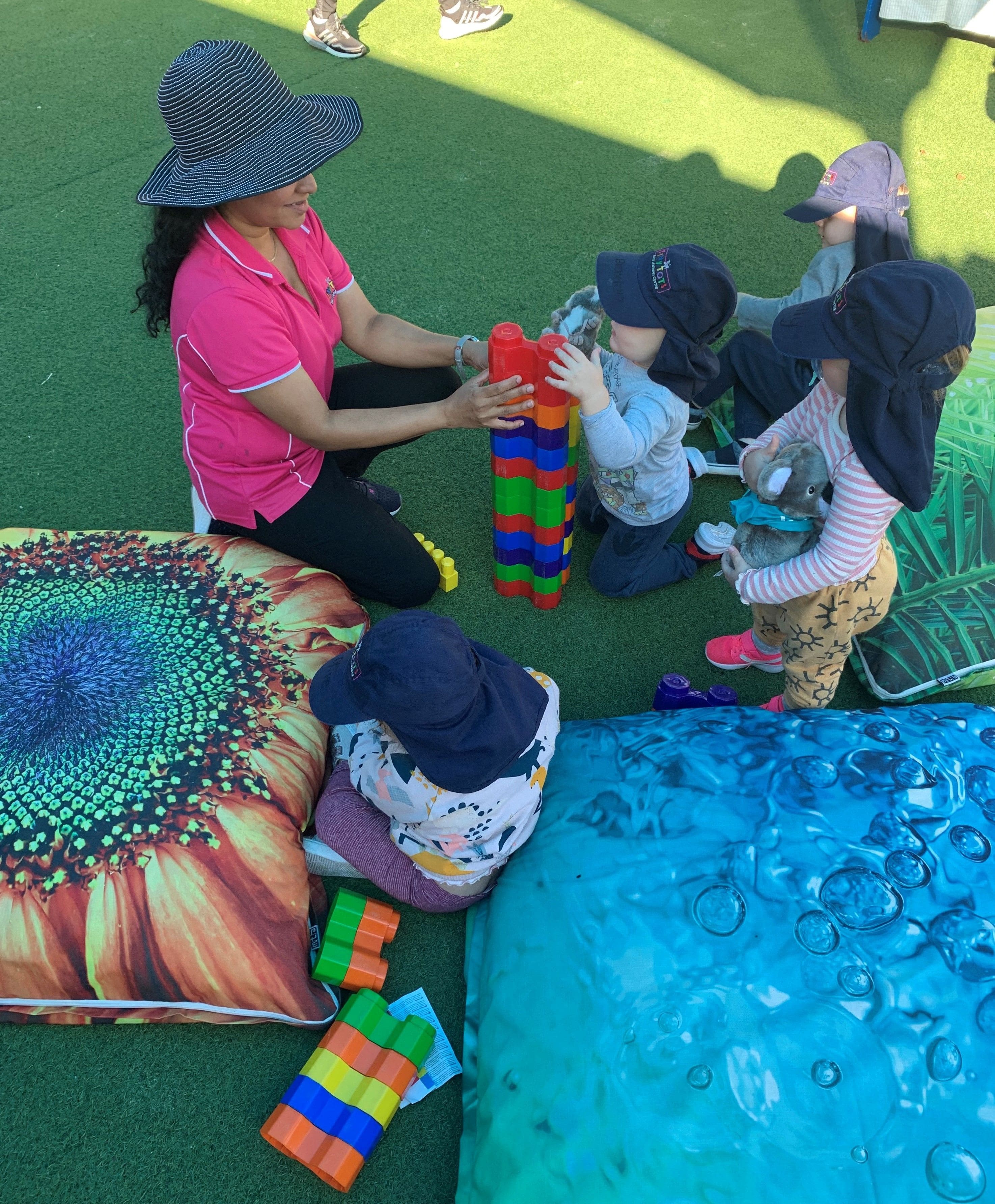 a teacher holding the tower blocks while senior kindy kids are playing in Tiny Tots Early Learning Centre